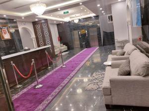un vestíbulo con sofás y una alfombra morada en سي مون قمر البحر, en Yanbu