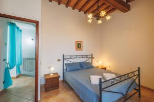 1 dormitorio con cama y lámpara de araña en Casa con posto auto coperto e ampio giardino en Lucignano