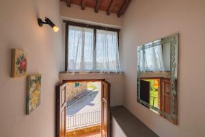 ルチニャーノにあるCasa con posto auto coperto e ampio giardinoの窓2つ、バルコニー付きのドアが備わる客室です。
