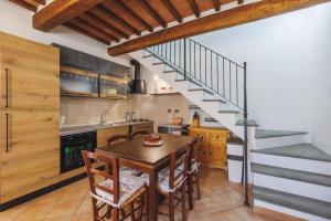 een keuken met een houten tafel en een trap bij Casa con posto auto coperto e ampio giardino in Lucignano
