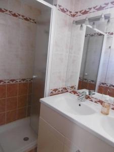 uma casa de banho com um lavatório e um chuveiro em HOLIDAYLAND NARBONNE PLAGE Villas 6 ou 7 PERSONNES AVEC TERRASSE ET PLACE DE PARKING PRIVATIVE em Narbona