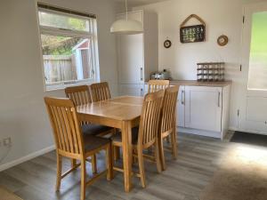 a dining room with a wooden table and chairs at Coldstream Cottage in Dale