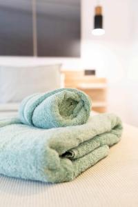 een stapel handdoeken bovenop een bed bij Apartamento Capri Living Suites en Castellon in Castellón de la Plana