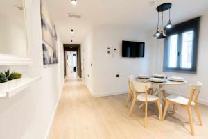 eine Küche und ein Esszimmer mit einem Tisch und Stühlen in der Unterkunft Apartamento Capri Living Suites en Castellon in Castellón de la Plana