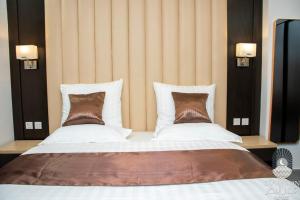 a bedroom with a large bed with two pillows at سي مون قمر البحر in Yanbu