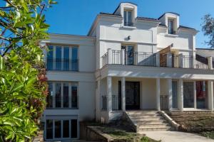 a white house with a staircase in front of it at 13.Studio#Creteil#Loft#Cinéma#Exclusif in Créteil