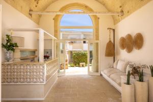 een woonkamer met een bank en een boog bij Masseria Bandino & Spa in Otranto