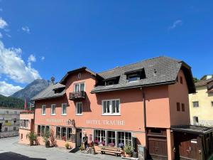 a building with a hotel in front of it at Hotel Traube in Scuol