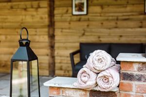 una pila de toallas rosas sentadas en una mesa junto a una lámpara en Shepherds Hut at Lythwood, en Shrewsbury