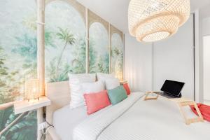 een slaapkamer met een bed met een laptop erop bij Green place Disneyland Paris in Bussy-Saint-Georges