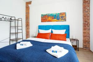 Un dormitorio con una cama azul con toallas. en FeelgooD Apartments DELUXE Zwickau CityCenter mit TG-Stellplatz, Netflix und Waipu-TV en Zwickau