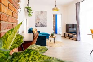 uma sala de estar com um sofá e uma televisão em FeelgooD Apartments DELUXE Zwickau CityCenter mit TG-Stellplatz, Netflix und Waipu-TV em Zwickau