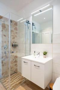 uma casa de banho com um lavatório branco e um chuveiro em FeelgooD Apartments DELUXE Zwickau CityCenter mit TG-Stellplatz, Netflix und Waipu-TV em Zwickau