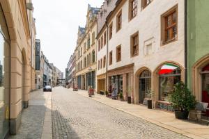 eine Kopfsteinpflasterstraße in einer Stadt mit Gebäuden in der Unterkunft FeelgooD Apartments DELUXE Zwickau CityCenter mit TG-Stellplatz, Netflix und Waipu-TV in Zwickau