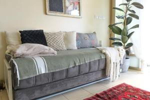 sala de estar con sofá y almohadas en פשוט מים. יחידה קסומה עם נוף מרהיב ובריכה מחוממת, en Gonen