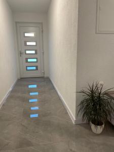 a hallway with a door with blue lights on the floor at Apartman Jurišić in Posušje