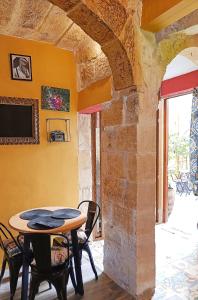 una mesa y sillas en una habitación con una pared de piedra en Fusion Homestay Accommodation, en Mosta