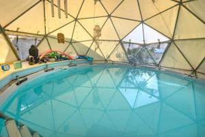 a large swimming pool inside of a dome house at פשוט מים. יחידה קסומה עם נוף מרהיב ובריכה מחוממת in Gonen