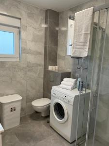 a bathroom with a washing machine and a toilet at Apartman Jurišić in Posušje