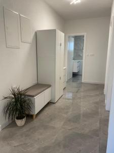 a room with a white cabinet and a potted plant at Apartman Jurišić in Posušje