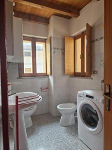 ein Badezimmer mit einer Waschmaschine und einem WC in der Unterkunft Giò Appartamenti Vacanze in Aymavilles