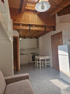 eine Küche mit einem Tisch und einem weißen Kühlschrank in der Unterkunft Giò Appartamenti Vacanze in Aymavilles