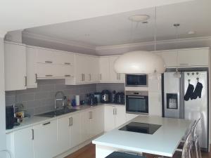 a kitchen with white cabinets and a white counter top at Family home with easy commute to London! in Croydon