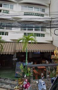 a building with a palm tree in front of a store at Orchid Residence in Patong Beach