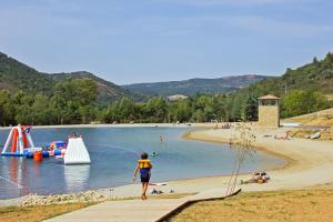 une personne se promenant sur une plage avec un parc aquatique dans l'établissement FranceComfort - L'Espinet, à Quillan