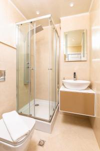 uma casa de banho com um chuveiro, um WC e um lavatório. em Cityscape Retreat 1BD Flat in the Heart of Plovdiv em Plovdiv