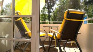 une chaise jaune et une table sur un balcon dans l'établissement Ostsee Ferienappartement Dierhagen-Strand, à Dierhagen
