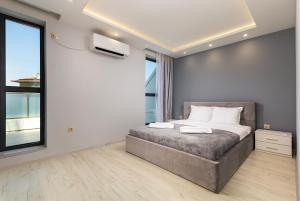 um quarto com uma cama e uma grande janela em Cityscape Retreat 1BD Flat in the Heart of Plovdiv em Plovdiv