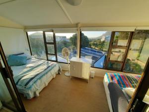 a bedroom with a bed and a large window at The Mermaid's Tail in Pringle Bay
