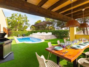 a dining table and chairs in a yard with a pool at Villa Tauler in Son Serra de Marina +32 photos