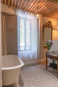 a bathroom with a tub and a window at Auberge des braconniers in Ampus