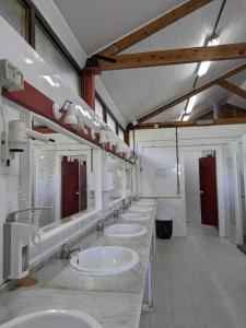 une rangée de lavabos dans une salle de bains commune dans l'établissement Kampaoh Cabo Blanco, à El Franco