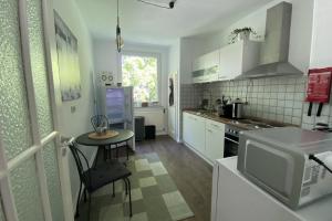 cocina con mesa pequeña y microondas en Private Apartment, en Hannover