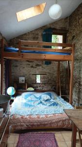 a bedroom with a bunk bed in a stone wall at Chambre insolite in Saint-Mathieu