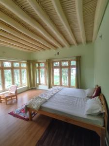 a bedroom with a large bed in a room with windows at Streamlet homestay in Leh
