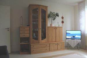un gran armario de madera en una sala de estar con TV en Ferienwohnung Am Walde 35177, en Hesel