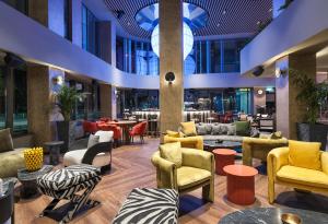 un vestíbulo con mesas y sillas coloridas en NYX Hotel Limassol by Leonardo Hotels, en Limassol