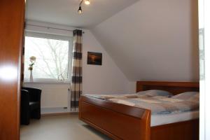 1 dormitorio con cama y ventana en Ferienwohnung Am Walde 35177, en Hesel