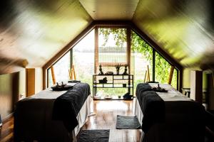 Dos camas en una habitación con una gran ventana. en Domaine de Bellevue, The Originals Relais, en Neufmoutiers-en-Brie 98 fotos más