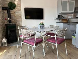 uma cozinha com uma mesa com quatro cadeiras e uma televisão em Villa Delfin em Vis