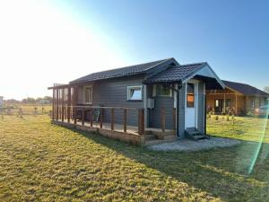 a small cabin in a field next to a field at Vasaras Sapnis in Nida