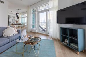 a living room with a blue couch and a tv at Frank Porter - The Lofts East in Dubai