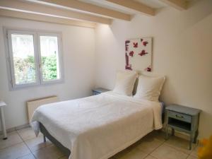 a bedroom with a white bed and a window at Maison Villa Yoda in Saint-Jean-de-Luz
