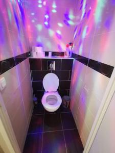 a bathroom with a toilet with purple and purple lights at Appartement Jelyad Mallard proche Disney in Chanteloup-en-Brie