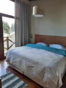 a bedroom with a large bed and a window at Pacha Home By A.M.A in San Carlos de Bariloche
