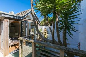 a wooden deck with a palm tree next to a house at Artist Cottage in St Ives